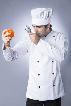 chef checking capsicum with magnifying glass 