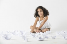 cute little girl playing with paper boat 