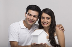 couple posing with toy home