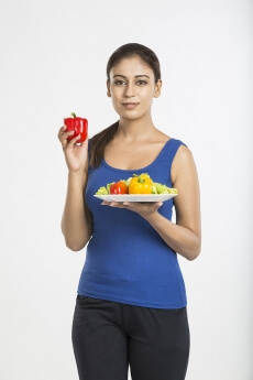 young woman red capsicum with full plate of vegetable