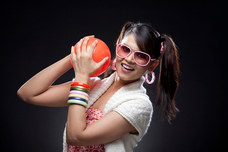 pigtail teenager posing with a small red ball