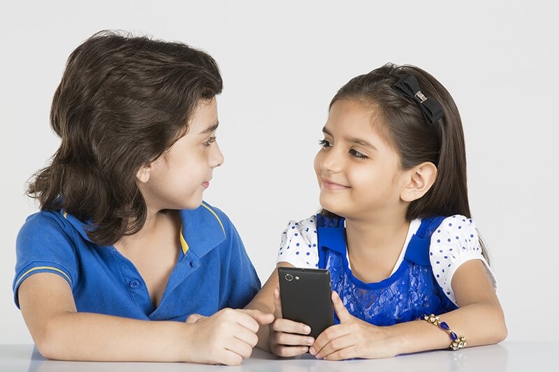 two kids playing with mobile phone