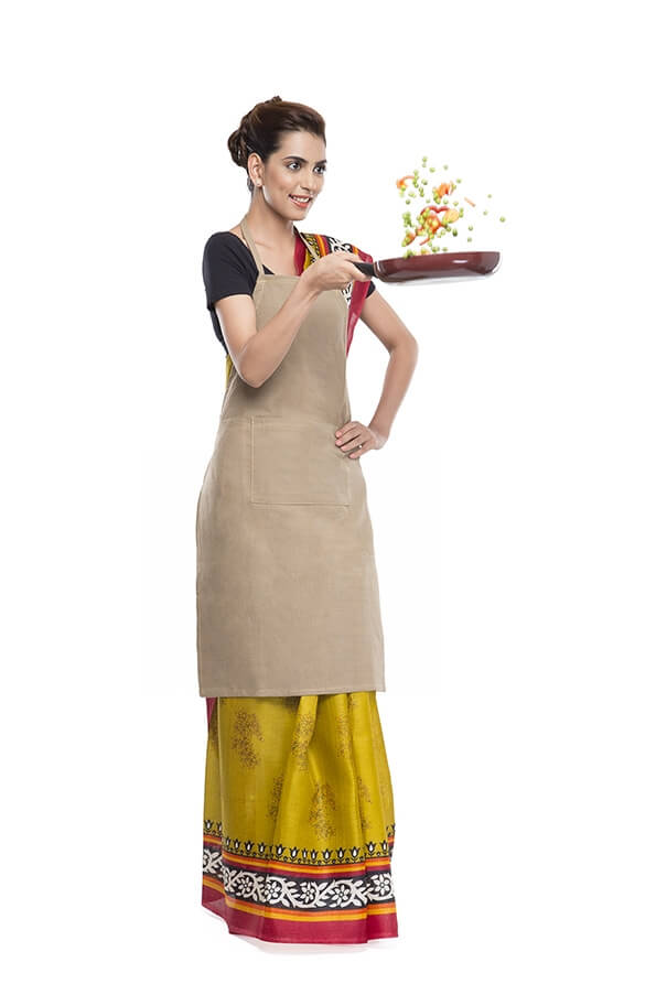 women wearing apron and tossing vegetables in fry pan